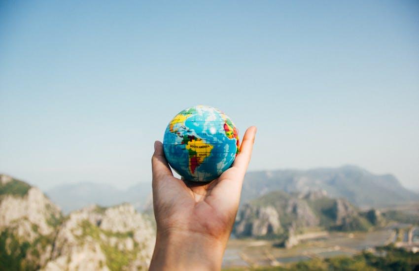 hand holding a small globe