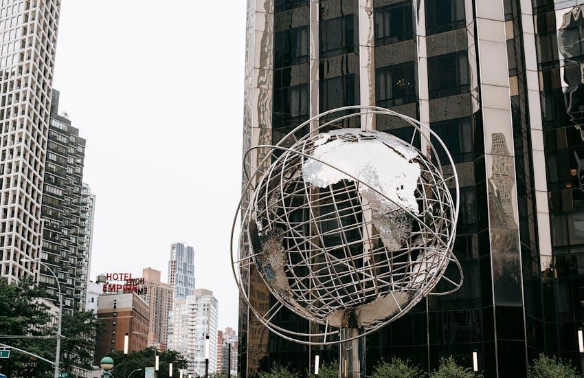 metal globe outside of a skyscraper