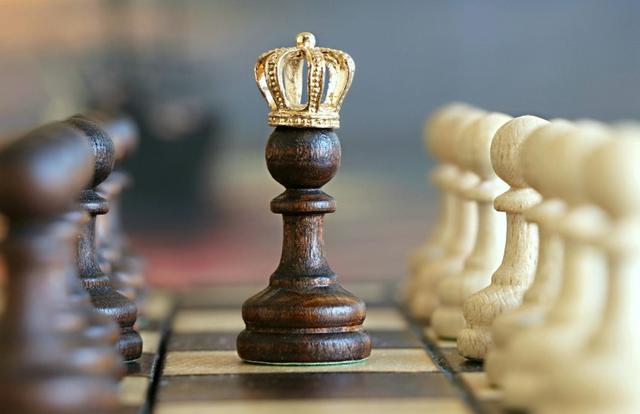 chess pawn with golden crown on it