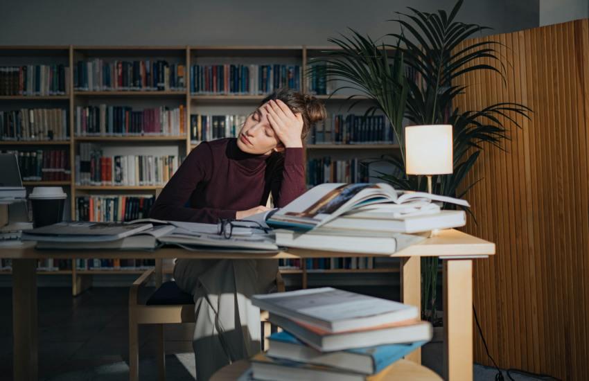 overwhelmed woman with lots of books