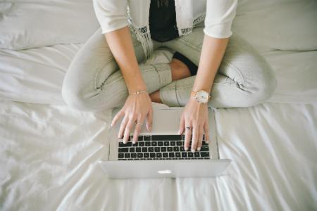 Girl sitting on bed writing a resume
