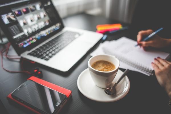 Creative professional desktop with laptop and coffee
