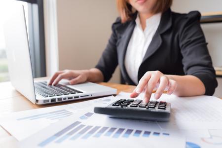 woman doing taxes with a calculator